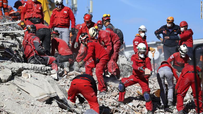Members of rescue services search in the debris of a collapsed building for survivors in Izmir, Turkey, Sunday, Nov. 1, 2020. Rescue teams continue ploughing through concrete blocs and debris of collapsed buildings in Turkey's third largest city in search of survivors of a powerful earthquake that struck Turkey's Aegean coast and north of the Greek island of Samos, Friday Oct. 30, killing dozens Hundreds of others were injured.(AP Photo/Darko Bandic)