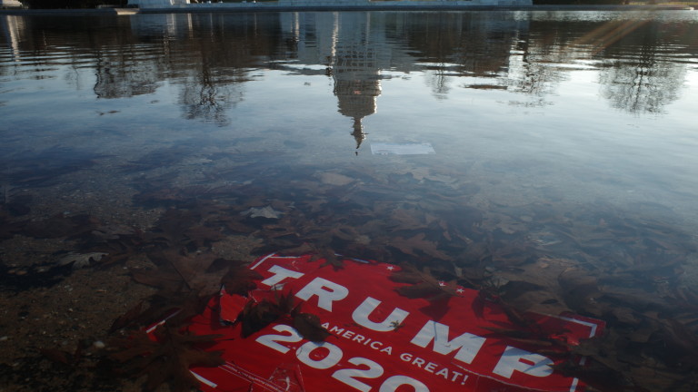 epaselect epa08925154 A 'Trump 2020' placard is submerged as the US Capitol Dome reflection is seen on the water of the US Capitol reflecting pool, in Washington, DC, USA, 07 January 2021, the morning after various groups of President Trump's supporters broke into the US Capitol and rioted as Congress met to certify the results of the 2020 US Presidential election.  EPA/GAMAL DIAB