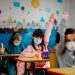 Elementary schoolchildren wearing a protective face masks  in the classroom. Education during epidemic.