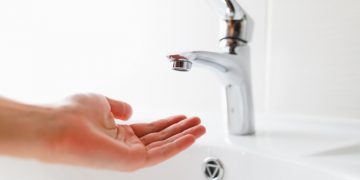 hand under faucet without water, close-up view
