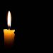 Single lit candle with quite flame on black background