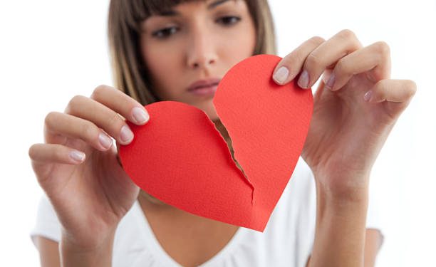 Pensive Girl breaking a paper heart.See similars: