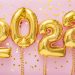 2021 year gold balloons on ribbons with confetti on pink wall. Happy New year 2021 eve celebration.
